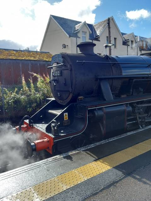 Steam locomotive on a sunny day at the station.