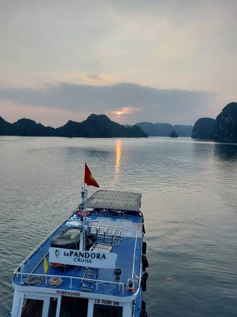 Sunset view from a boat in a bay with calm waters.