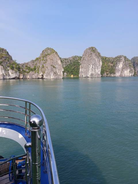 Boat cruising through calm waters with rocky outcrops nearby.