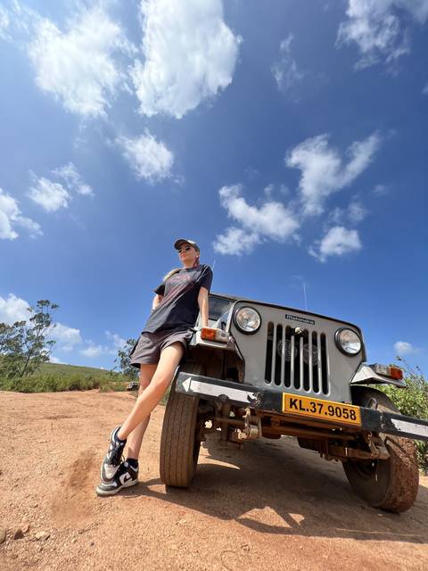 Woman posing with an off-road vehicle against a blue sky.