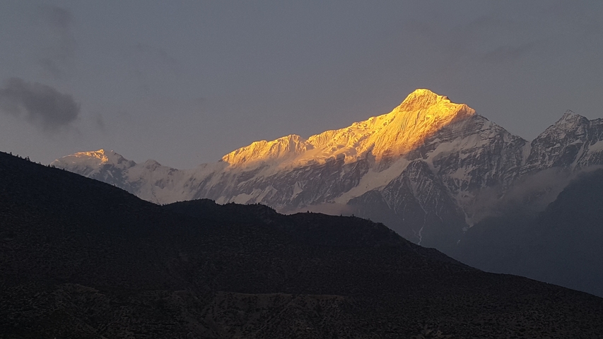       Golden sunrise illuminating snowy mountains.
  