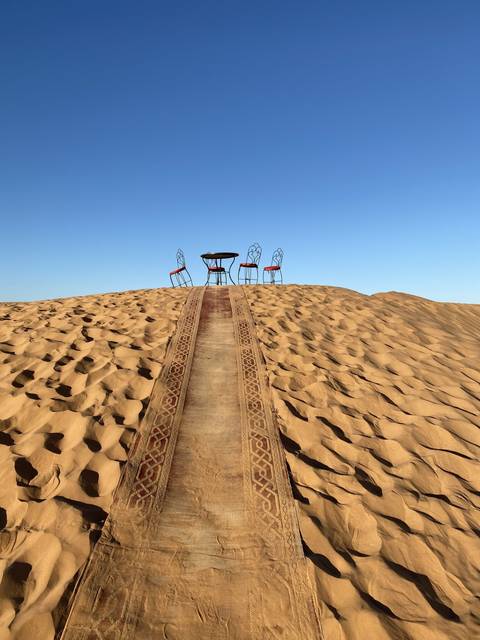 Chairs set up under a clear sky in the desert.