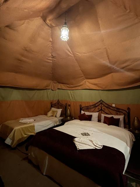       Interior of a tent with beds and soft lighting.
  