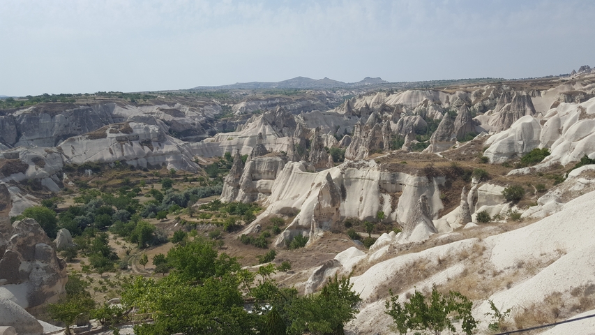 Rock formations in a valley under a clear blue sky.
