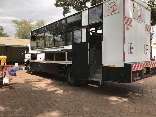 A side view of a large truck with open compartments.
