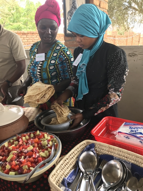 Individuals preparing traditional flatbreads in a kitchen setting.