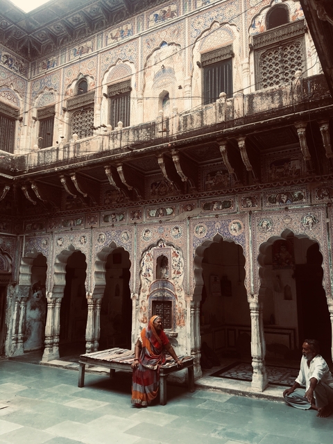       Building facade with intricate and colorful murals and arches.
  
