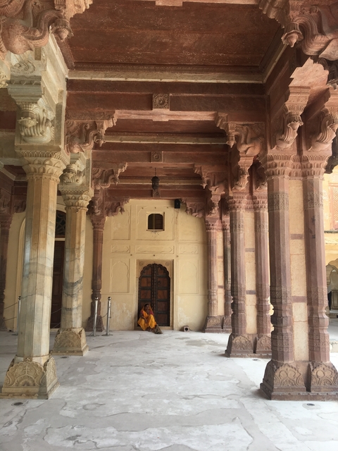       Woman in traditional attire engaging in a ritual in the water.
  