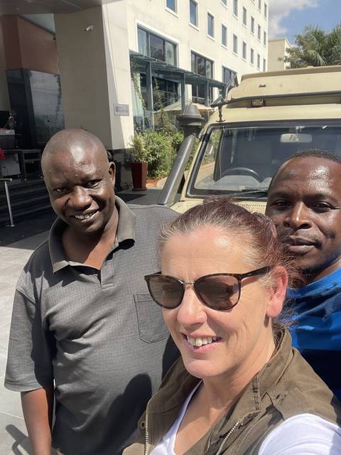       Group selfie with three people smiling in front of a building
  