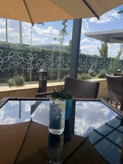       A glass of drink on a table with outdoor view
  