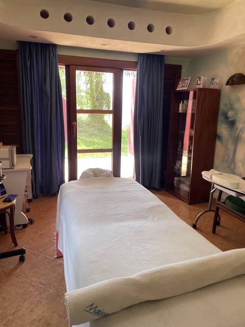 Interior of a room with a bed and closed curtains.