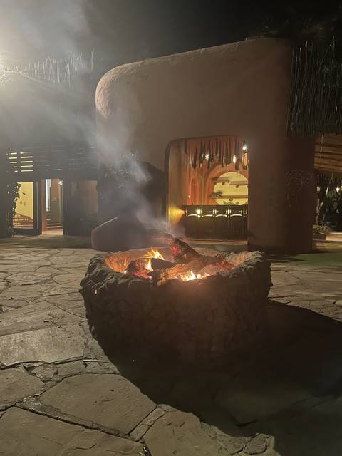       Bonfire outside a traditionally designed building.
  