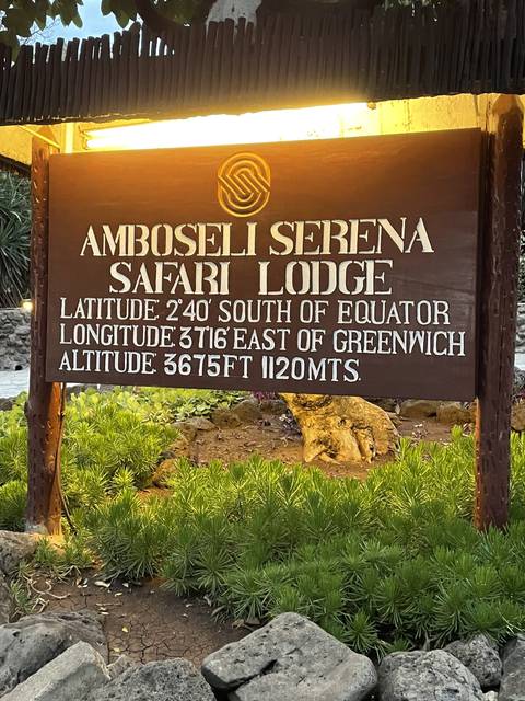       Sign for Amboseli Serena Safari Lodge with plant decorations.
  