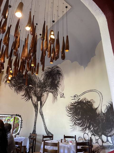       Artistic murals on walls in a dining area.
  