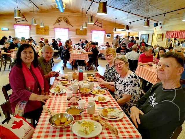 Group dining in a casual restaurant with checkered tablecloths.