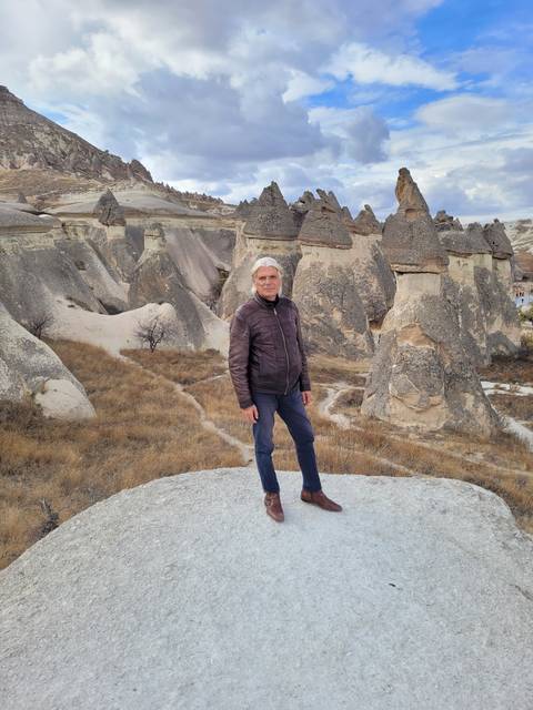       A person in a landscape with unique rock formations.
  