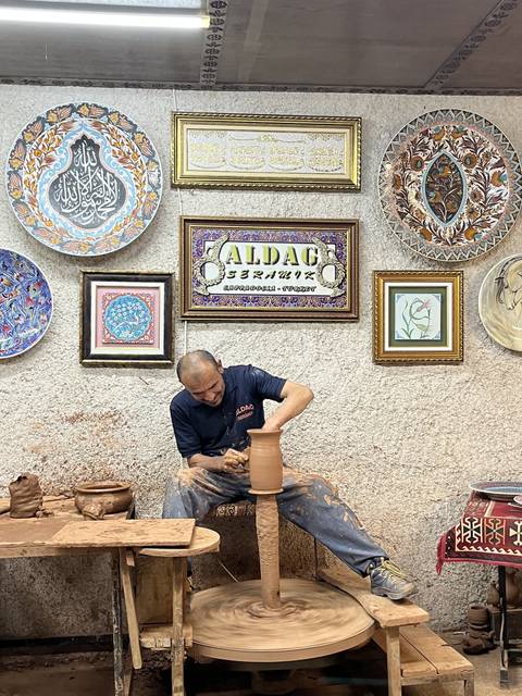       Person working on pottery in a decorated workshop
  