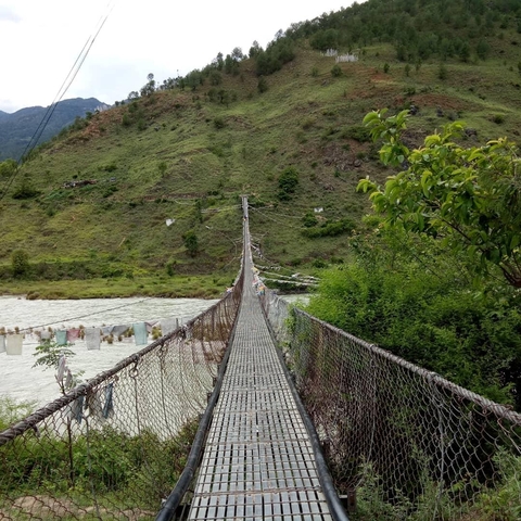       Suspension bridge over a river in a hilly area
  