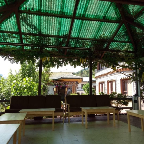       View from a sheltered outdoor area with Bhutanese architecture.
  