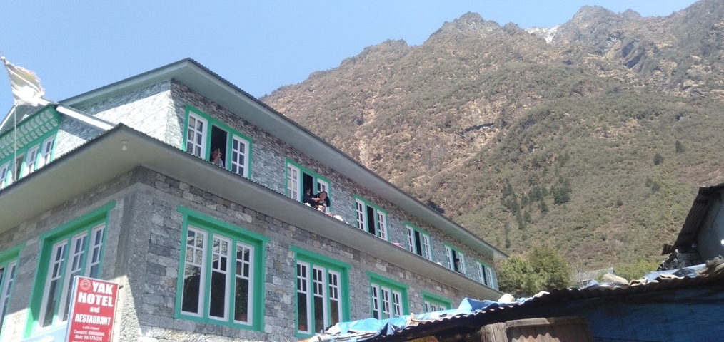 Building labeled Yak Hotel in a mountainous area.