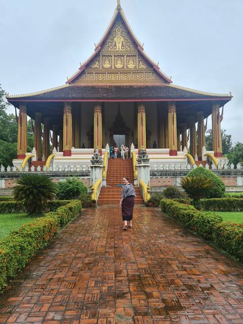       Person walking in front of a traditional temple.
  