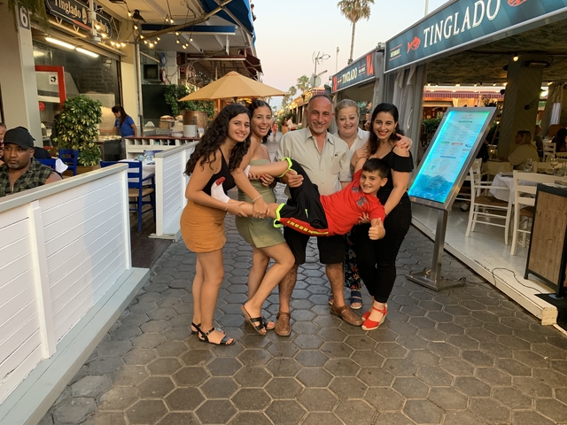 Smiling family posing with a child held horizontally.