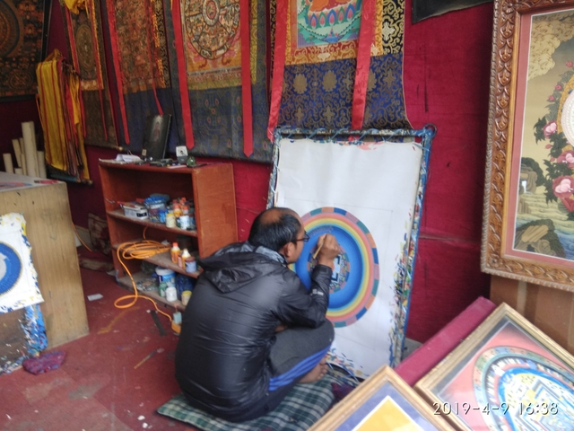       Person painting a mandala in a workshop.
  
