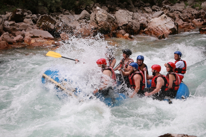 Group of people rafting in a fast-flowing river.