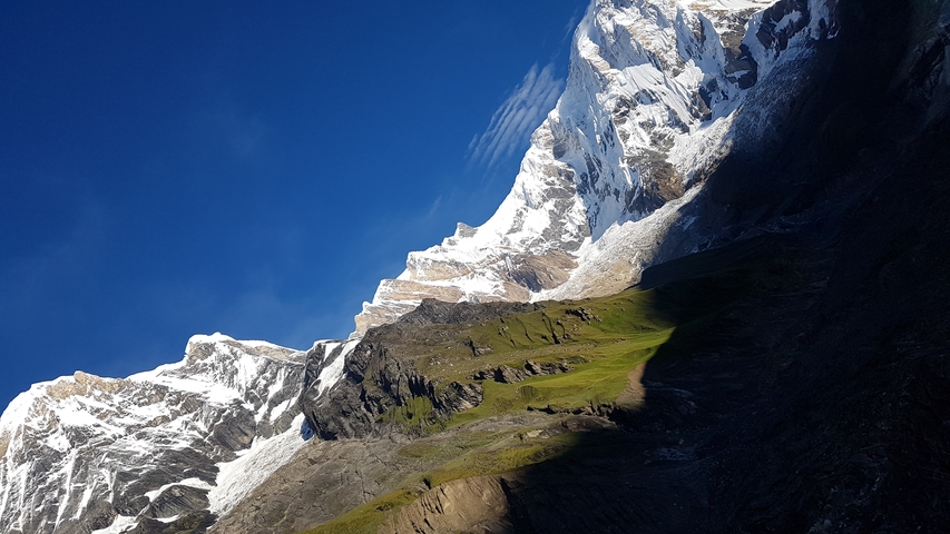 Snow-covered mountain peaks under a clear blue sky.