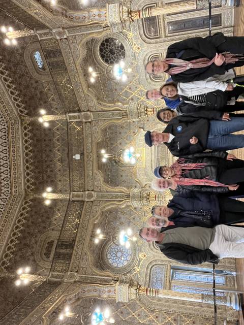 Group standing inside an ornately decorated building.