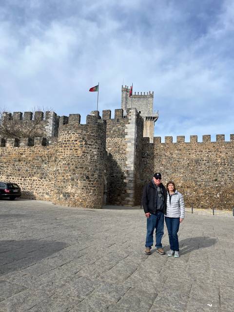Upside-down image of two people standing next to a castle exterior.