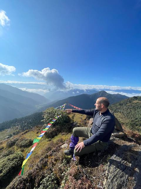 Person in the mountains with prayer flags.