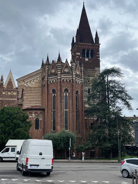 Large brick church with gothic architecture, different perspective.