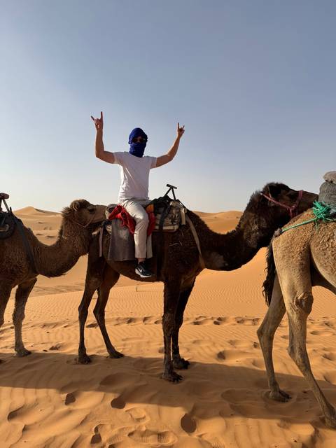 Person riding a camel in the desert.