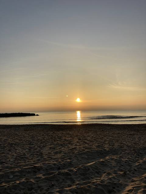Sunset over a sandy beach.