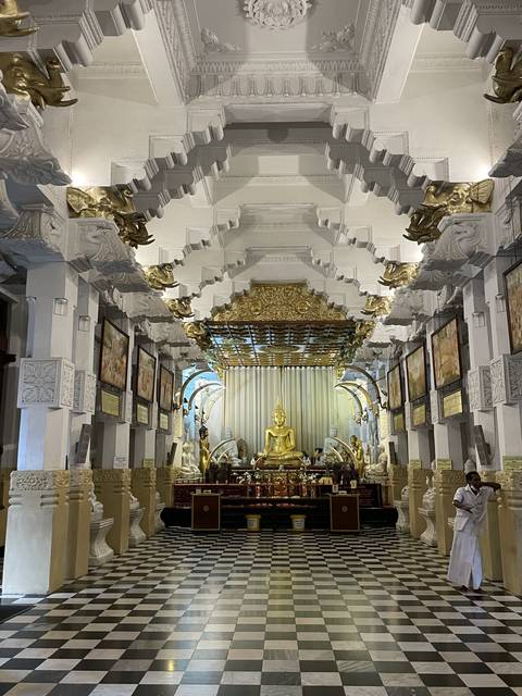 Ornate interior with gold decorations and a Buddha statue.