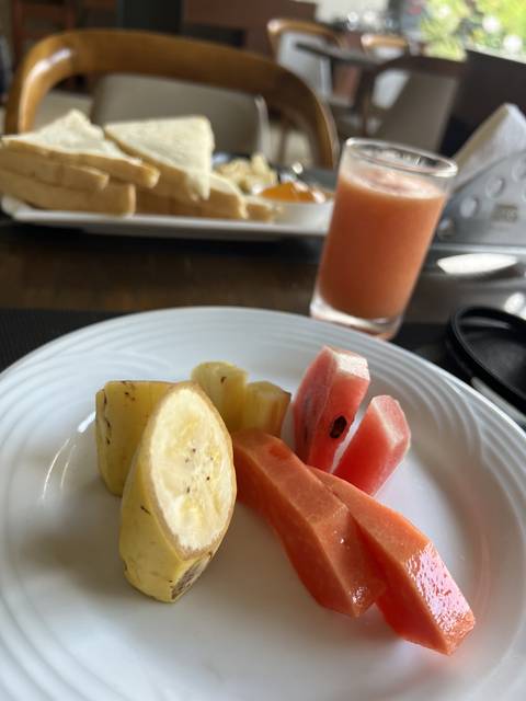       Plate with assorted fruits and a glass of juice.
  