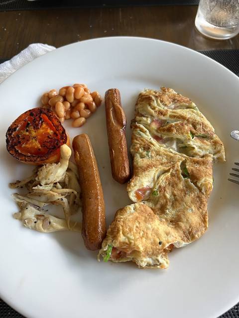 Breakfast plate with sausages, beans, and omelette.