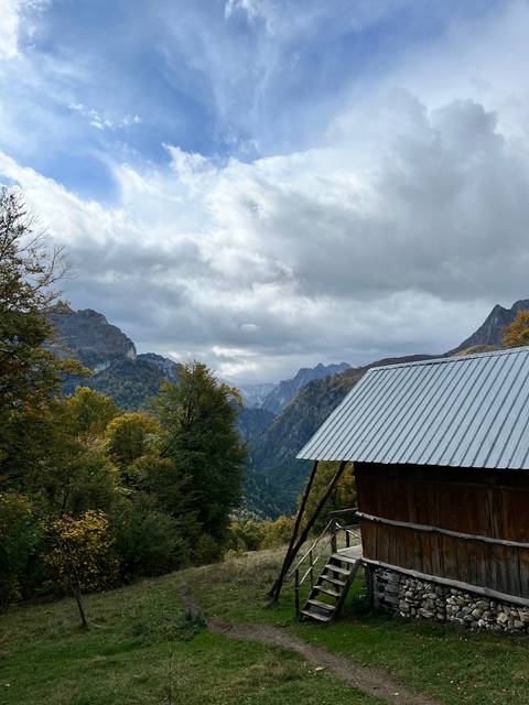       Alpine scene with a cabin and mountains.
  