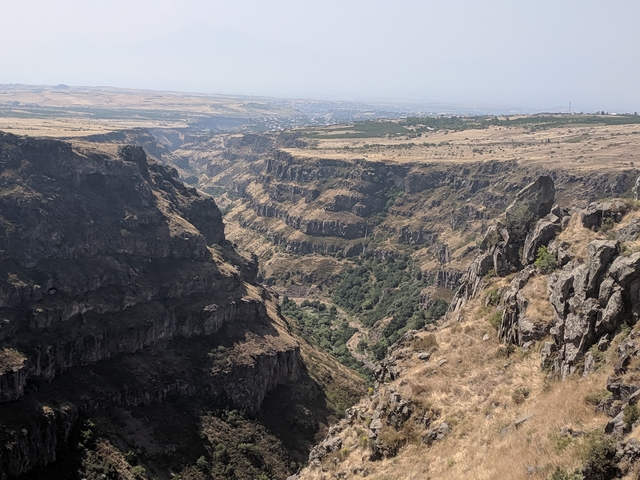       Deep canyon with rocky walls and vegetation seen from an elevated view.
  