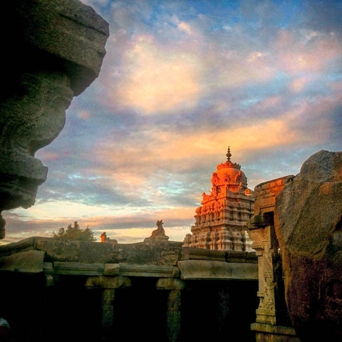       Temple structure with intricate carvings and sunset sky.
  