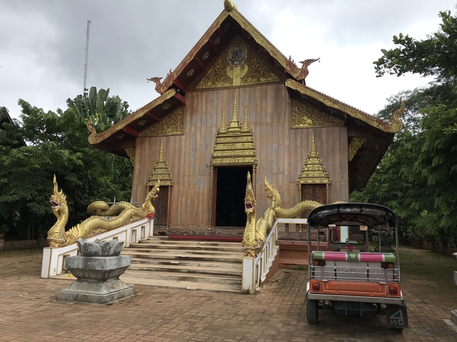       Thai temple with intricate dragon carvings.
  