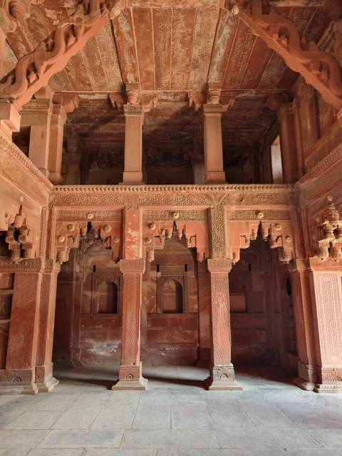 Interior of a historical building with sandstone carvings.