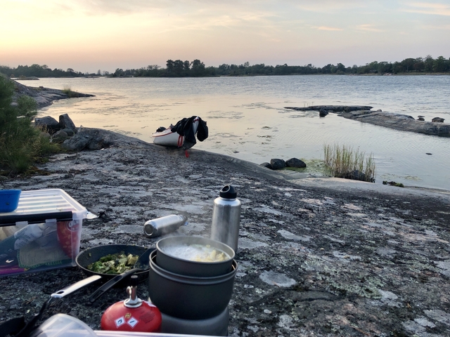 Camping setup with cookware by the water