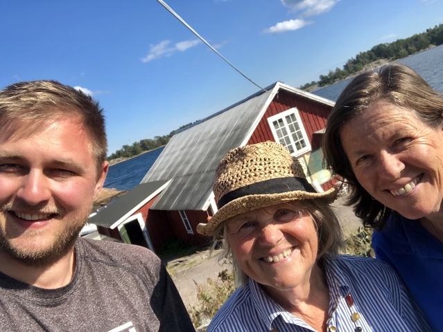 Smiling group taking a selfie with a red wooden cabin