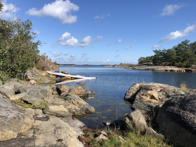 Kayaks on a rocky shore with a clear blue sky