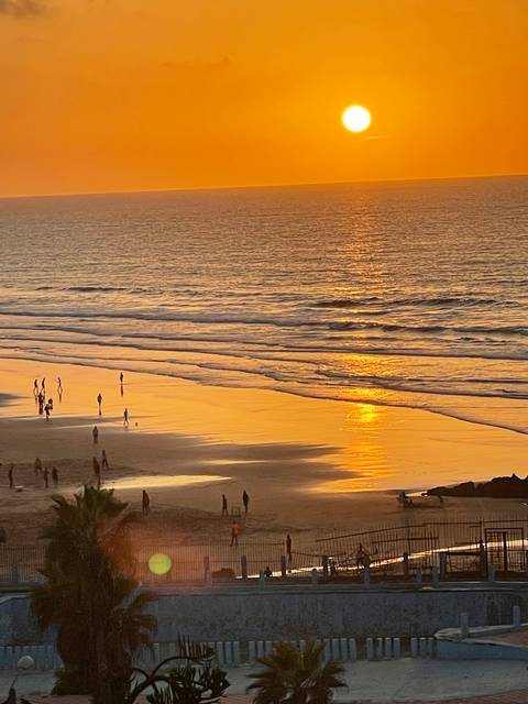       Sunset view over a beach with ocean waves.
  