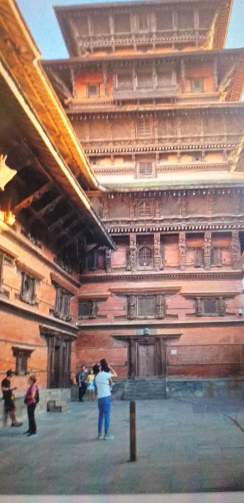 Large red-brick historic building with people in the courtyard.