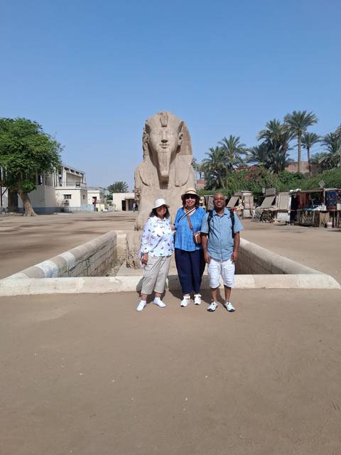 People posing before a sphinx statue.