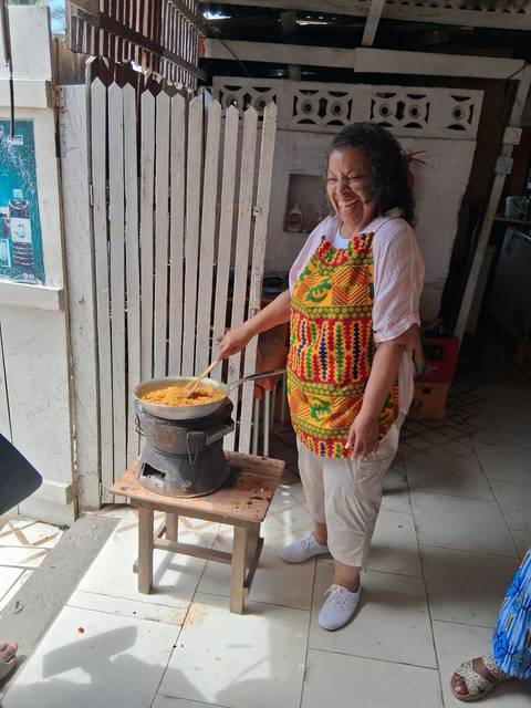 Woman cooking with a traditional pot on a charcoal stove.